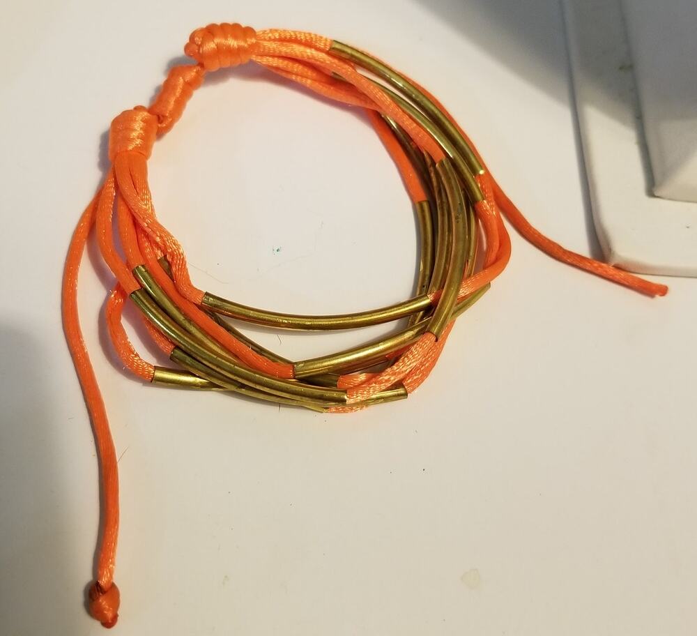 Bright orange multi strand bracelet textile cords and gold tone tubes adjustable